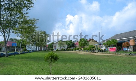 Natural View Of A School Yard With Green Grass And Several Buildings