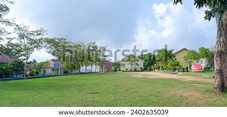 Natural View Of The School Yard With Green Grass And Several Buildings During The Day