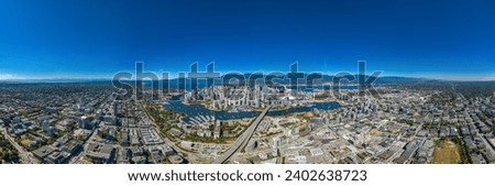 An aerial panoramic shot of the city of Vancouver with modern buildings and a port with moored boats