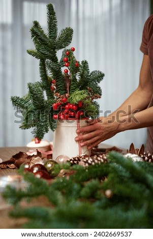 Woman making Christmas arrangement with fir branches. craft handmade decor.