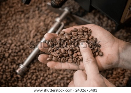 fresh coffee beans roasted spinning cover professional machine close up to soft focus slow shutter speed because want to make motion blur of coffee beans detail concept at factory Nan Thailand