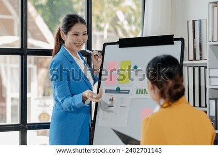 Confident female professional discussing with colleagues, Professional business executive managers working using laptop computer sitting at table, discussing digital strategy at corporate meeting.