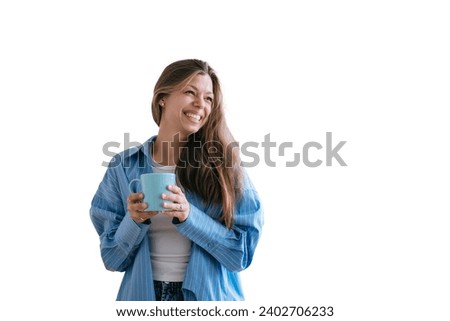 Happy caucasian female with long loose hair in jeans and blue shirt toothy smiles holds cup of tea looks aside happily enjoys weekend stands against transparent background. Pretty hispanic woman