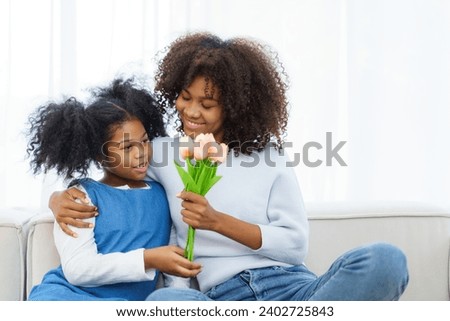 Lovely cute little girl gives mother a bouquet of flower in the international Mother's Day, American - African black ethnic family portrait. International Mother's Day concept.