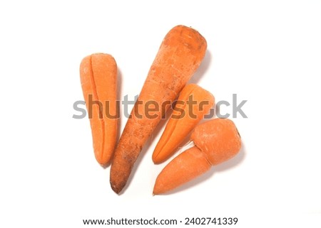 Four damaged substandard carrots white background Royalty-Free Stock Photo #2402741339