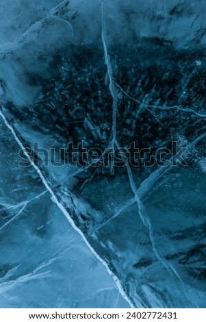 Top vies of a texture cracks transparent ice on a Baikal lake on a snowy winter day. Natural background  Royalty-Free Stock Photo #2402772431