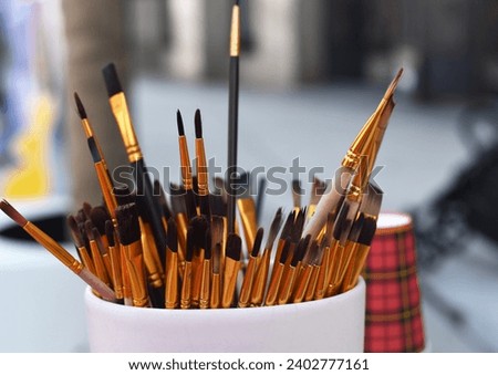 Many different brushes in a vase
