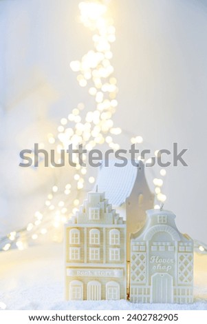 Christmas scandinavian houses ornament. Space for text. Christmas winter still life. Natural Christmas decorations for home. Vertical. Snow flakes. Candle and burning warm lights. White miracle. Fairy