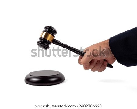 Close up shot of a judge's hand holding a gavel to make a decision isolated on a white background. Auction hammer with wooden stand. The concept of law and justice. Royalty-Free Stock Photo #2402786923