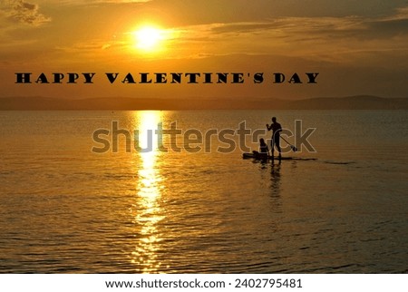 Happy Valentine's Day banner card. Two lovers on paddleboard in sunset. Copy space for more placement of text. Royalty-Free Stock Photo #2402795481