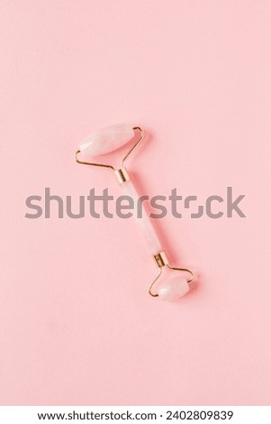 Pink Rose Quartz Facial Roller on Pink Background