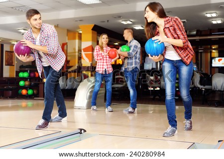 Young friends playing in bowling alley