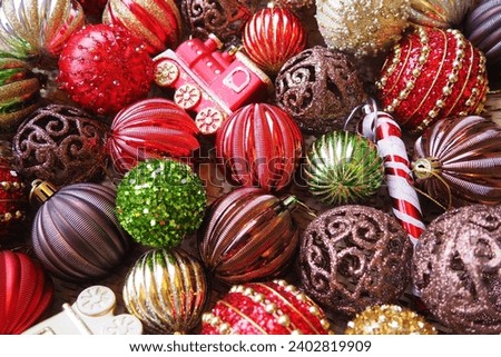 New Year's Christmas balls and decorations close up. A lot of decor of gold, red, yellow, brown, green, silver. Striped Christmas balls lie in a bunch. Festive beautiful colorful background. Design