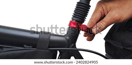 Red color aluminum bicycle clamp open with a hand isolated on a white background