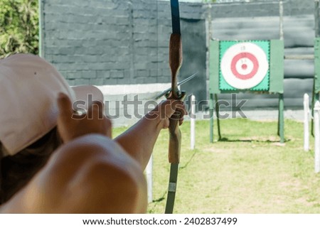 practicing the sport of archery training good aim outdoors to hit the target Royalty-Free Stock Photo #2402837499