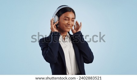 Headphones, studio or happy businesswoman listening to music isolated on blue background. Dance, smile or calm female person streaming a radio song, sound or audio on online subscription to relax