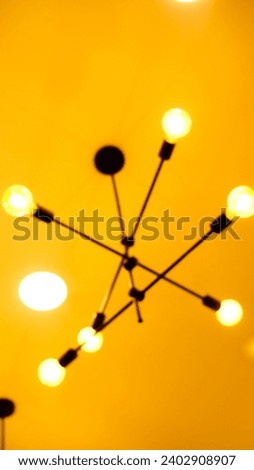 interior decorative lamp with three stems supporting six brightly lit bulbs
