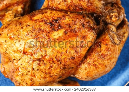 Whole chicken cooked in the oven. Close up photo with a tasty looking chicken cooked at grill and ready to be served.