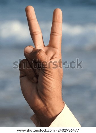 Victory's symbol is showing by fingers.