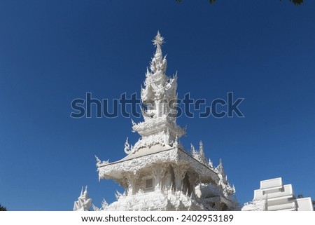 A white temple stands tall against a clear blue sky.