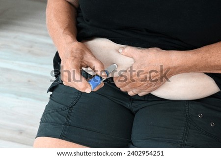Women injecting semaglutide into her stomach Royalty-Free Stock Photo #2402954251