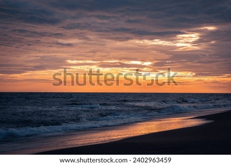 Wet surfline of black beach landscape photo. Beautiful nature scenery photography with bright sky on background. 