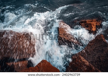 Close up water with stones on the beach concept photo. Stormy sea, waves, pebbles under water. The view from the top, nautical background. High quality picture for wallpaper
