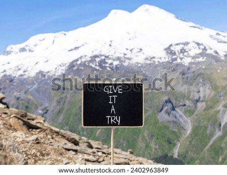 Give it a try symbol. Concept word Give it a try on beautiful black chalk blackboard. Beautiful mountain Elbrus background. Business give it a try concept. Copy space.