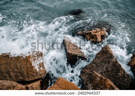 Winter stormy seaside close up concept photo. Water with stones on the beach. Underwater rock. The view from the top, nautical background. High quality picture for wallpaper