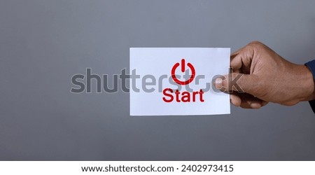 Hand picks up a piece of paper with the text "start" and an icon. Startup concept. Start up.
