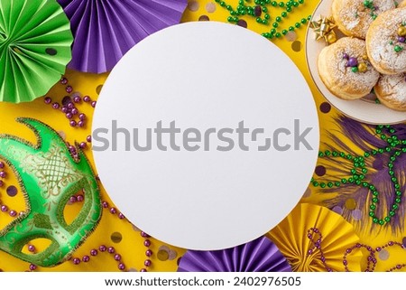 Sweet Celebration Extravaganza: Top view of delightful treats, lavish carnival mask, beaded necklaces, feathers, confetti against yellow background with circle for advert. Dive into Mardi Gras spirit