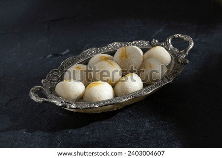 Rasgulla is a one of famous Indian sweet made by Pure Cow milk. This sweet is served chilled and has soft-spongy  Royalty-Free Stock Photo #2403004607