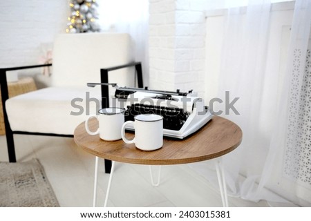 A white armchair and a table with a typewriter in a cozy, bright interior. Business concept