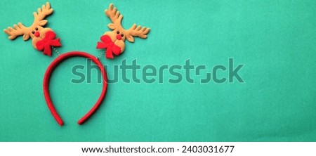 cute Christmas headbands with christmas reindeer horns isolate on a greenbackdrop. concept of joyful Christmas party,New year is coming soon, festive season decoration with Christmas elements