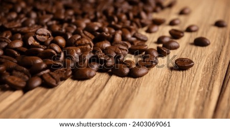 Close-up of roasted coffee beans on wooden background Royalty-Free Stock Photo #2403069061