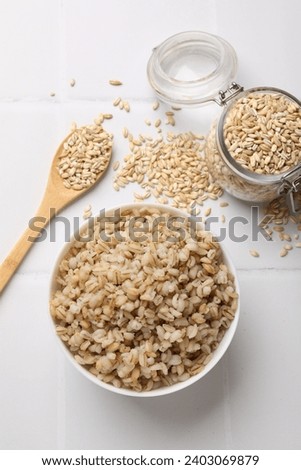 Delicious pearl barley served on white tiled table, flat lay Royalty-Free Stock Photo #2403069879