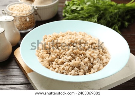 Delicious fresh pearl barley on wooden table, closeup Royalty-Free Stock Photo #2403069881