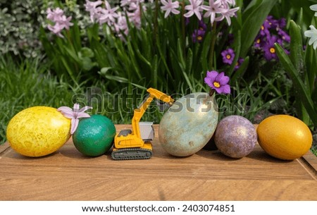 model of a toy excavator with bright, painted multi-colored eggs. Easter spring holiday concept for construction companies. Business greeting card. copy space
