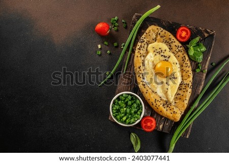 Khachapuri with egg on wooden background. Georgian cuisine. top view. copy space for text. Royalty-Free Stock Photo #2403077441