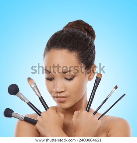 Woman, grooming and makeup brushes for cosmetics in studio, choice and decision for beauty. Female model person, tools and equipment for application, skincare and facial treatment by blue background
