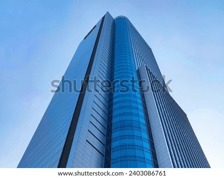 Low angle view of skyscraper with glass window and clear blue sky background for business and finance concept Royalty-Free Stock Photo #2403086761