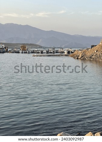 Pictures of fishing boats in the sea surrounded by mountains