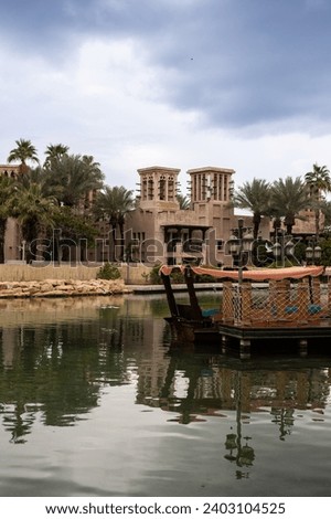Waterways of Madinat Jumeira and a traditional Arabian boat abra to take a ride.  Royalty-Free Stock Photo #2403104525