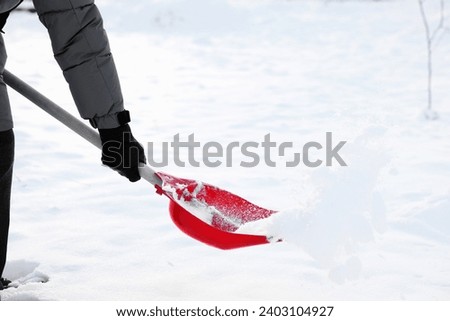Man removing snow with shovel outdoors, closeup Royalty-Free Stock Photo #2403104927