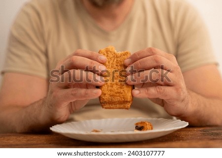 male hands holding a chocolate puff over the table