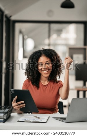 Excited african, american woman sitting at table feeling happy black woman overjoyed accepting mail at laptop promoted at home surprised girl reading good news.