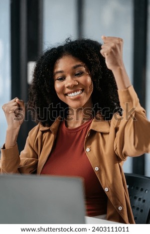 Overjoyed charming excited black woman business woman worker using smartphone and laptop working in office, feeling happy.