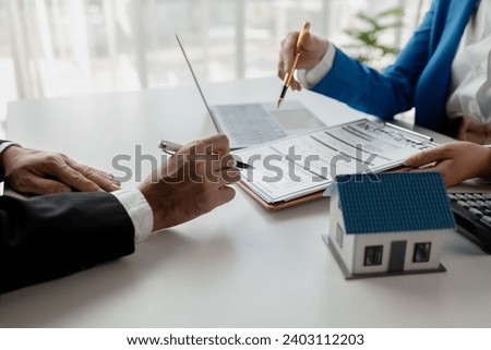 House insurance paperwork, A realtor is explaining home insurance documents to a buyer in his office at the company, Sign home insurance documents, make an agreement together.