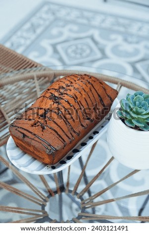 Vertical image of marbled pudding with chocolate served on porcelain plate on glass table in restaurant, pastry concept for social networks and websites