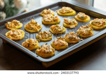 cut raw potatoes adorned with delicious stuffing, arranged in a tray and ready to cook